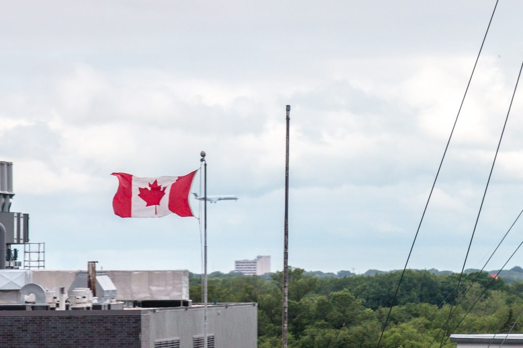 Holiday Hours for July 2016 10 In Background Plane Passes Canadian Flag